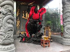 01C Statue of a Warrior God wearing a red sash standing on a dragon fish at the entrance to the Wong Tai Sin temple Hong Kong